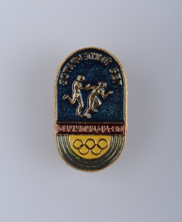 Olympische Spiele Moskau 1980 Abzeichen mit zwei Läufern und fettem "Olympische Spiele"-Text darüber.