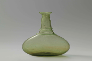 Ein grüner Glasweinkelch mit Stopfen, zylindrischer Form, breiter Basis, engem Hals und detaillierten Verzierungen, mit einem glänzenden Finish.