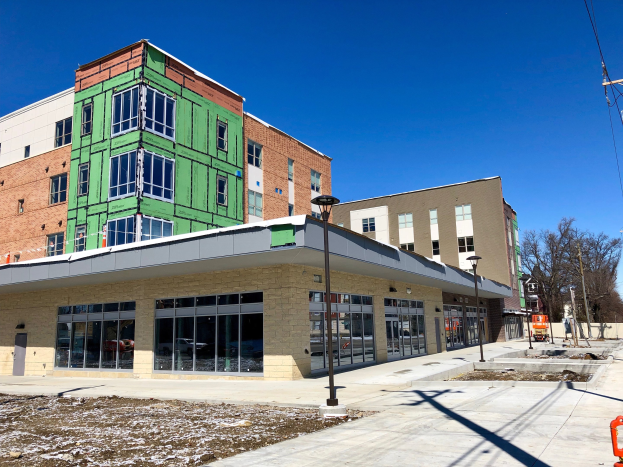 Großes mehrstöckiges Gebäude mit zahlreichen Fenstern, Teil des University of Wisconsin-Madison-Campus, umgeben von Straßeninfrastruktur, Fahrzeugen, Bäumen und einem bewölkten Himmel.