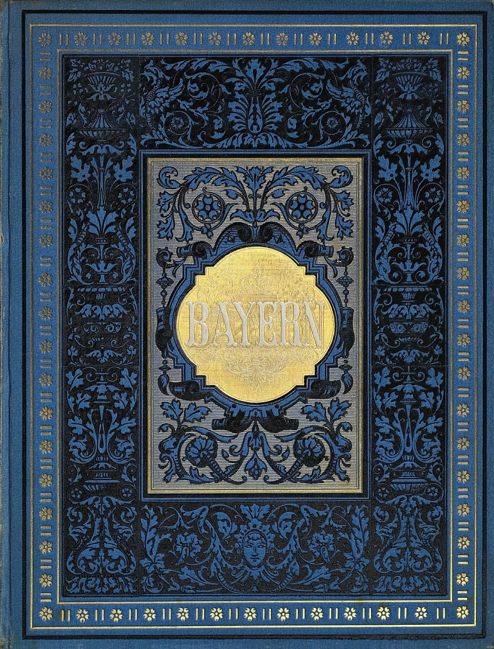 Ein blau-goldenes Buch mit der Aufschrift "Bayern" auf dem Cover, das mit detaillierten Verzierungen versehen ist.