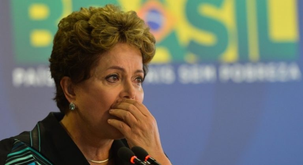 Brasiliens Präsidentin Dilma Rousseff spricht auf einer Pressekonferenz in Rio de Janeiro vor einer Tafel mit Text und mehreren Mikrofonen.