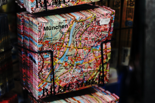 Open book with a detailed map of Berlin, Germany, featuring a cityscape surrounded by trees and buildings under a cloudy sky.