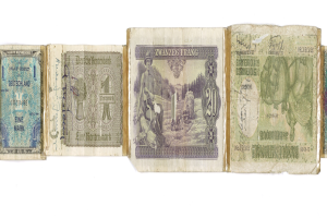 Ein Stapel alter deutscher Banknoten verschiedener Nennwerte auf einem alten Buch.