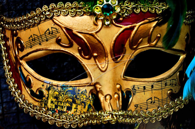 Ein Close-up eines Karnevalsmasken mit Musiknoten, detaillierten Designs und Federn.