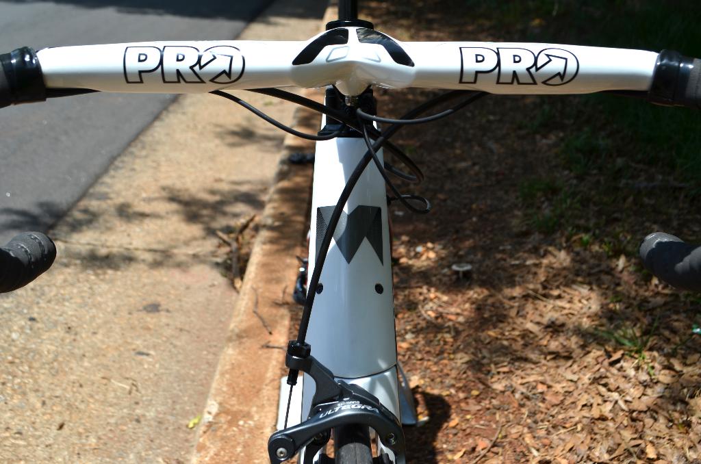 Ein Fahrrad ist mittig positioniert, auf der linken Seite ist eine Straße zu sehen.