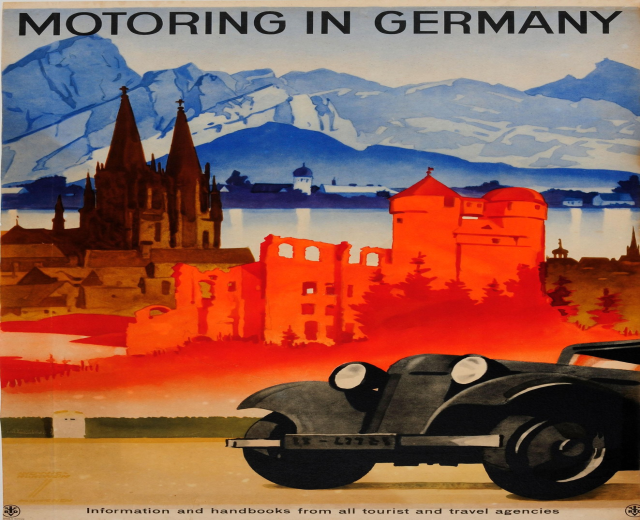 Poster in Germany advertising a motorbike, with a car in the foreground, buildings, water, and mountains in the background, and text on the poster.