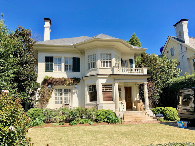 Large white house with a lawn, trees, and plants in front, a vehicle parked to the right, and sky visible above, located in Los Angeles, California, listed for sale.