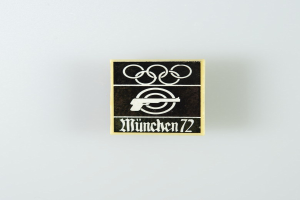 Black and white logo for "München 1972" featuring a circle with a stylized figure and outstretched arms, and bold text in a sans-serif font.