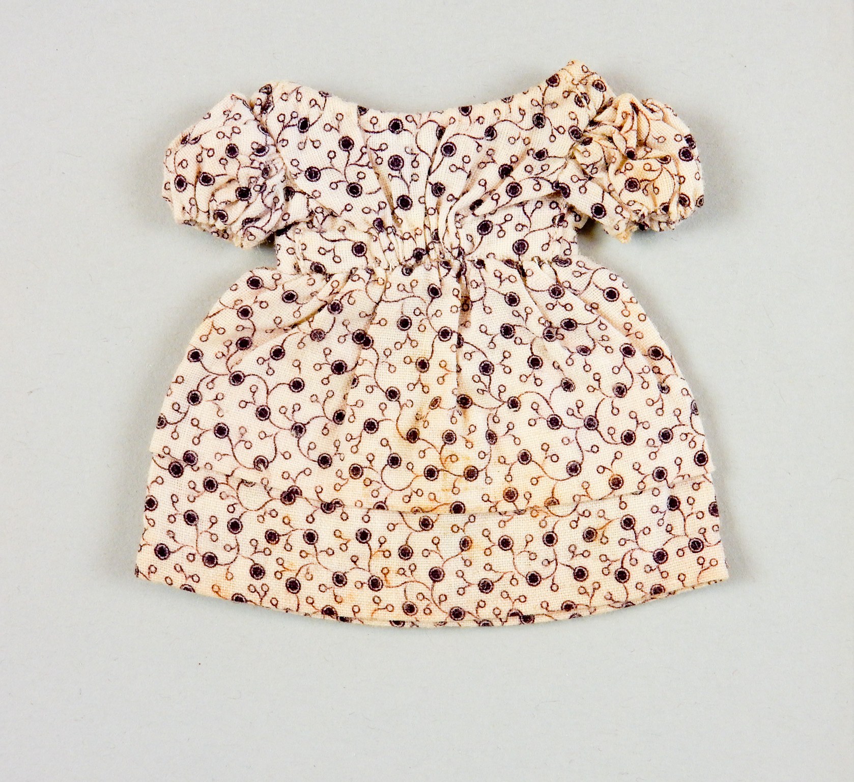 Weißes Sommerkleid mit Kniehöhe und runder Halsausschnitt, kurzen Ärmeln und einem Volumenrock, das ein komplexes mehrfarbiges Muster auf einem leichten Stoff aufweist, auf einer weißen Oberfläche präsentiert.