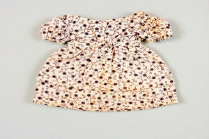 Weißes Sommerkleid mit Kniehöhe und runder Halsausschnitt, kurzen Ärmeln und einem Volumenrock, das ein komplexes mehrfarbiges Muster auf einem leichten Stoff aufweist, auf einer weißen Oberfläche präsentiert.