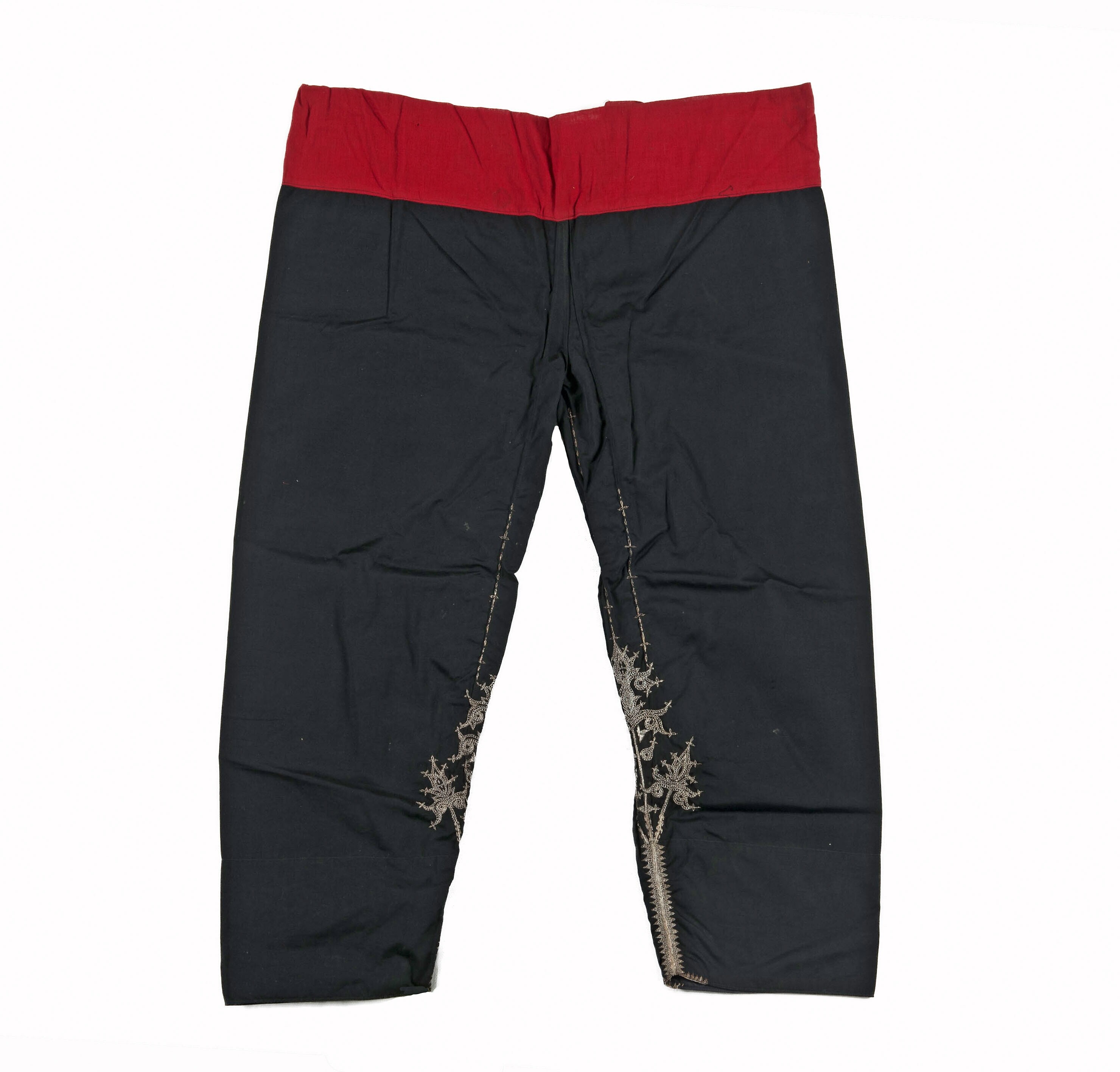 Schwarze und rote Slim-Fit-Hose mit goldener Stickerei, mit Zuziehband und zwei Seitentaschen, vor weißem Hintergrund.