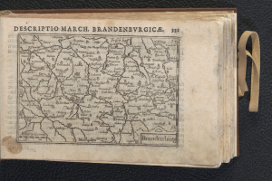 Ein offenes Buch, das eine detaillierte Karte der geografischen Merkmale Brandenburgs auf einer schwarzen Oberfläche zeigt.