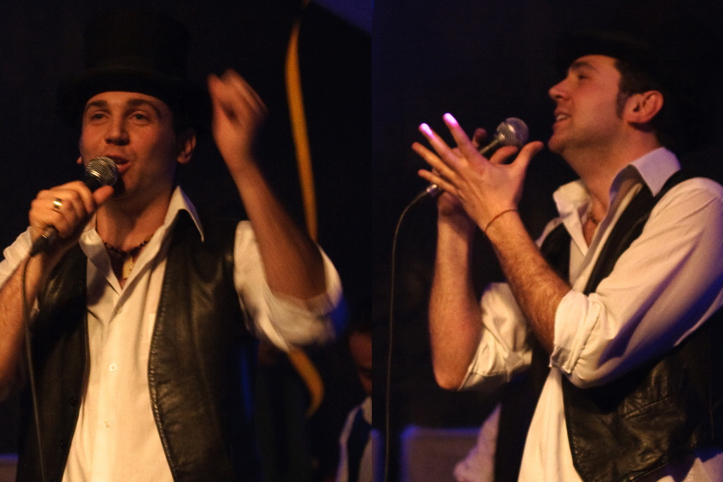 Eine Gruppe von Menschen mit zwei Personen, die in Mikrofone singen.