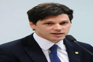 Ein Mann in Anzug und Krawatte spricht in ein Mikrofon an einem Rednerpult, wahrscheinlich um ein Regierungsgesetz zur Verbannung des Internets zu unterstützen.