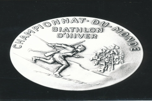 Silberne Medaille mit einer Gravur eines Skiläufers, mit Text, auf schwarzem Hintergrund.