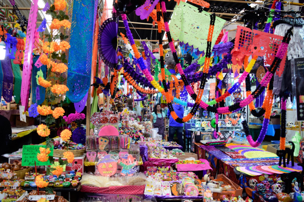 Ein belebter Markt mit Ständen, die Spielzeug, Deko-Artikel und andere Gegenstände verkaufen, Menschen, die herumlaufen, und Deckenbeleuchtung.