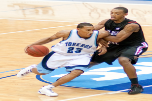 Zwei Personen spielen Basketball, eine hält den Ball in der Mitte.