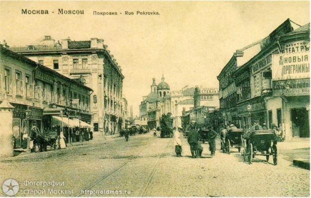 Black and white photo of a Moscow city street with pedestrians, horse carts, buildings, signboards, lampposts, and text at the top and bottom.