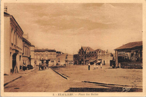 Black and white photo of a city street labeled "Place des Halles" with buildings, people, carts, poles, trees, and a sky in the background.