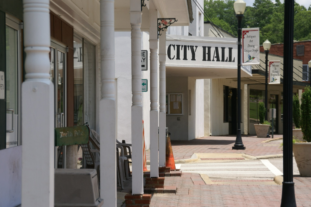 Stadtverwaltung von Gebäuden, Straßeninfrastruktur, Fahrzeugen und Vegetation umgeben.