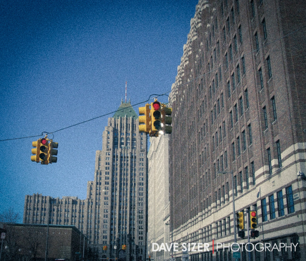 Mehrere Ampeln an Masten vor Gebäuden angebracht.