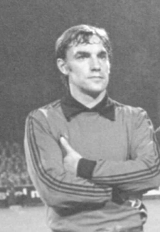 Black and white photo of a man standing on a soccer field with arms crossed, surrounded by seated spectators, believed to be the legendary Manchester United goalkeeper who died at age 89.