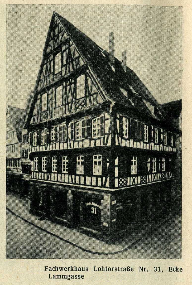 Black and white photograph of a half-timbered building labeled "Fachwerkhaus Lohtorstraße nr 31, Eke" on a street with sky in the background.